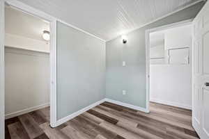 Unfurnished bedroom with vaulted ceiling, a closet, and wood-type flooring