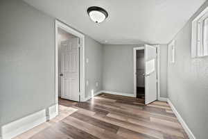 Unfurnished bedroom featuring a textured ceiling and hardwood / wood-style flooring