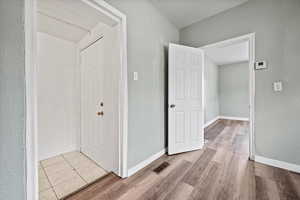 Corridor with light hardwood / wood-style flooring