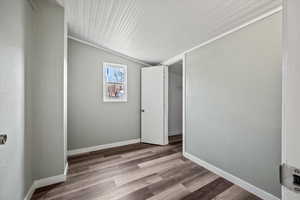 Interior space with light hardwood / wood-style floors, crown molding, and vaulted ceiling