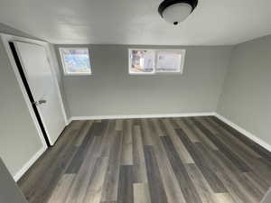 Spare room featuring a textured ceiling and dark hardwood / wood-style floors