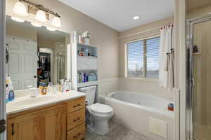 Full bathroom with tile patterned flooring, vanity, toilet, and independent shower and bath