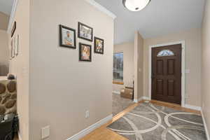 Entrance foyer featuring hardwood / wood-style floors and crown molding