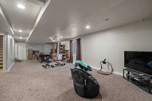 Exercise room with carpet floors and a textured ceiling