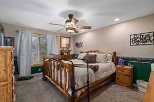 Carpeted bedroom featuring ceiling fan