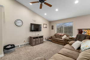 Living room featuring carpet flooring, ceiling fan, and lofted ceiling