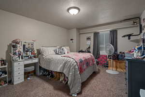 Carpeted bedroom with a textured ceiling