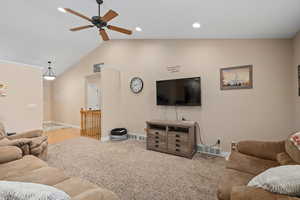 Living room with light carpet, ceiling fan, and vaulted ceiling