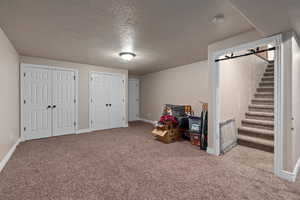 Game room with light carpet and a textured ceiling