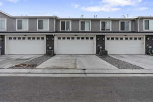 View of back of property with central AC and a garage