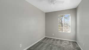 Carpeted empty room with ceiling fan