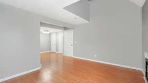 Unfurnished room featuring light wood-type flooring and an inviting chandelier