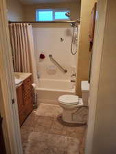 Full bathroom with tile patterned flooring, vanity, shower / bath combo, and toilet