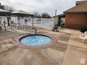 View of swimming pool featuring a hot tub and a patio area