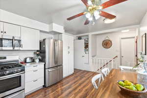 Kitchen featuring white cabinetry, dark wood-type flooring, and stainless steel appliances