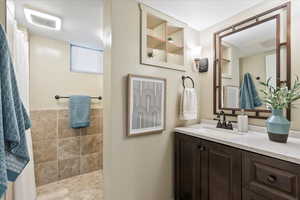 Bathroom with vanity, tile patterned floors, and tile walls