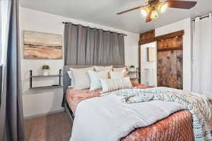 Carpeted bedroom with ceiling fan