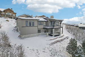 Snow covered property with a balcony