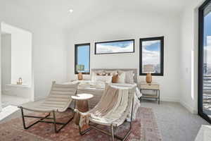 Carpeted bedroom featuring vaulted ceiling