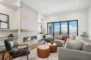 Living room featuring a mountain view, a large fireplace, and hardwood / wood-style flooring