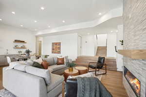 Living room with light hardwood / wood-style flooring, a stone fireplace, and sink