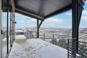 Snow covered deck featuring a mountain view