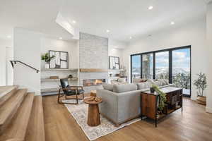 Living room featuring a mountain view, a stone fireplace, and light hardwood / wood-style flooring