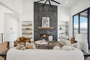 Living room with hardwood / wood-style flooring, built in shelves, a large fireplace, and a mountain view