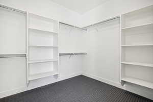 Spacious closet with dark colored carpet