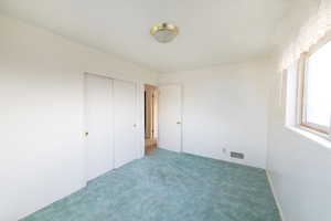 Unfurnished bedroom with carpet flooring and a closet