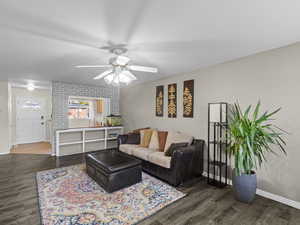 Living room with ceiling fan and dark hardwood / wood-style flooring