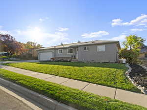 Single story home with a garage and a front yard