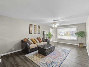 Living room with dark hardwood / wood-style floors and ceiling fan