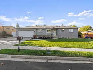 Single story home featuring a garage and a front lawn