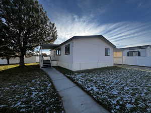 View of property exterior with a wooden deck and a yard