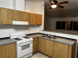 Kitchen featuring ceiling fan, white range with gas cooktop, and sink