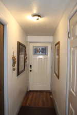 Duplex # A Entryway featuring a wall mounted air conditioner, dark hardwood / wood-style flooring, and a textured ceiling