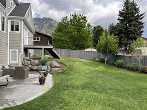 View of yard with a patio area, an outdoor living space, and a deck with mountain view