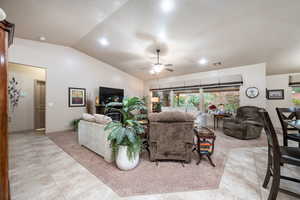 Living area with vaulted ceiling, a ceiling fan, recessed lighting, and light tile patterned floors