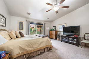 Bedroom with light colored carpet, lofted ceiling, and a ceiling fan