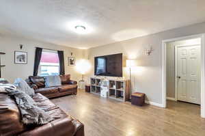 Living room featuring light hardwood / wood-style flooring and a textured ceiling