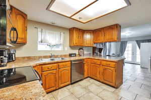 Kitchen with dishwasher, french doors, kitchen peninsula, and sink