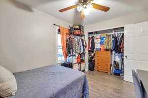 Bedroom featuring hardwood / wood-style floors, ceiling fan, and a closet