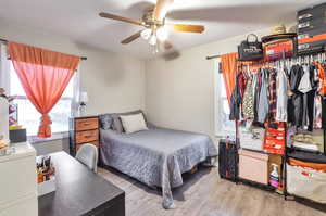 Bedroom with ceiling fan and hardwood / wood-style flooring