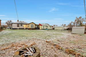 View of yard with a fire pit and a shed