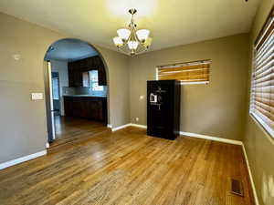 Unfurnished dining area featuring a chandelier, light wood-type flooring, plenty of natural light, and sink