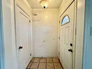 Doorway to outside featuring light tile patterned flooring