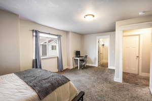 Bedroom with carpet and a textured ceiling