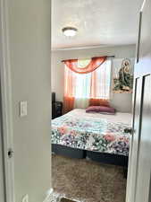 Carpeted bedroom with a textured ceiling