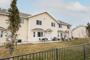 Back of house with a patio, a lawn, and central air condition unit